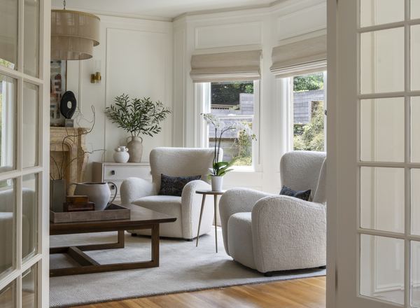Sunlit living room with hardwood floors and tall windows